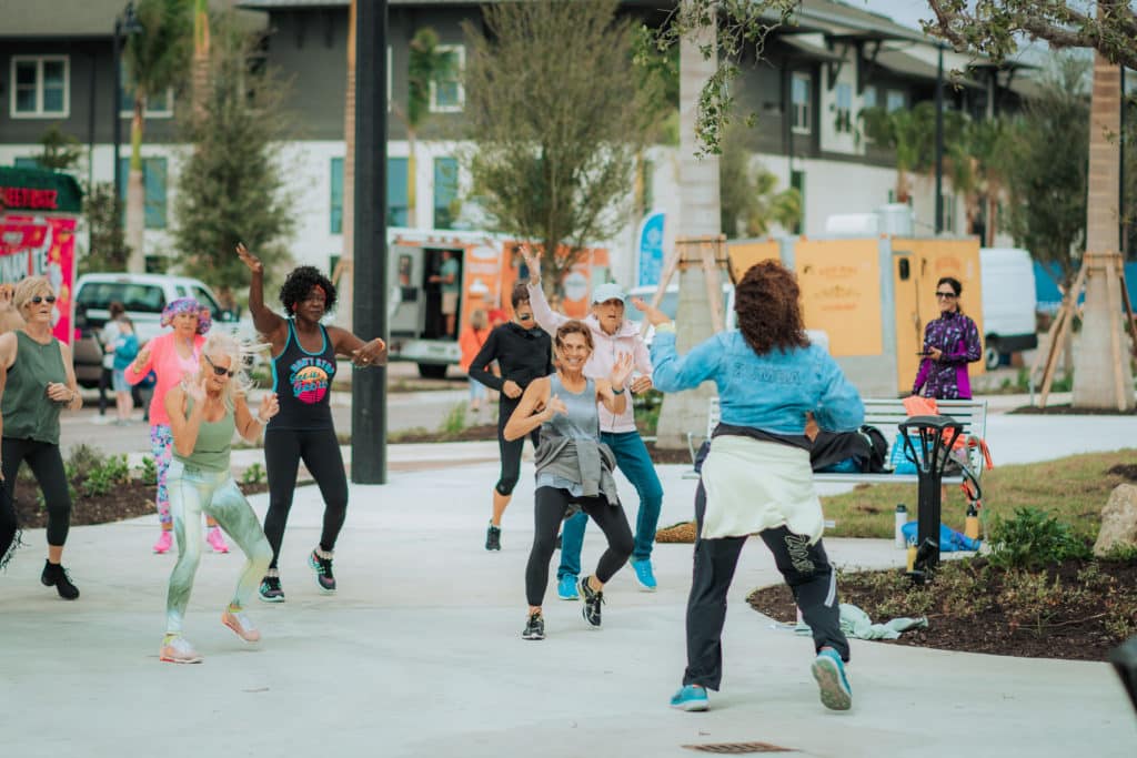 People dancing on pavement during Zumba class in Downtown Wellen at Wellen Park Florida