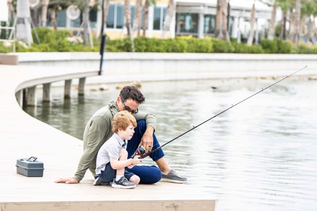 A man and a little boy are fishing on Grand Lake at Wellen Park.