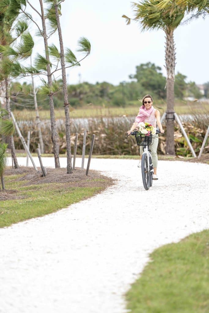 A woman is riding a bike on a trail at Wellen Park.